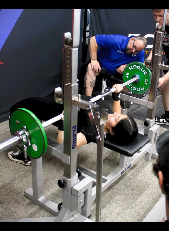 Fatima performing the bench press during competition