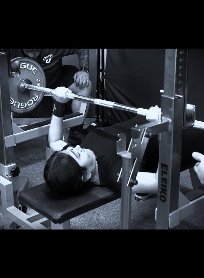 Fatima during the bench press in a monochrome-style image